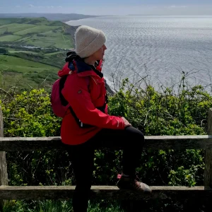 Sue in red coat looking out to sea