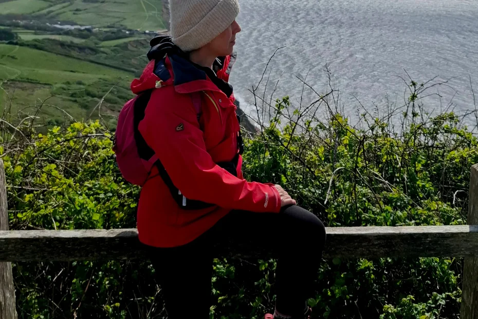 Sue in red coat looking out to sea